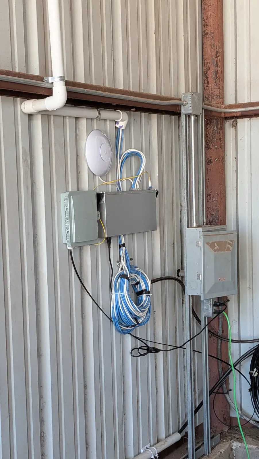 Access point and network enclosure installed on the interior wall of a metal building