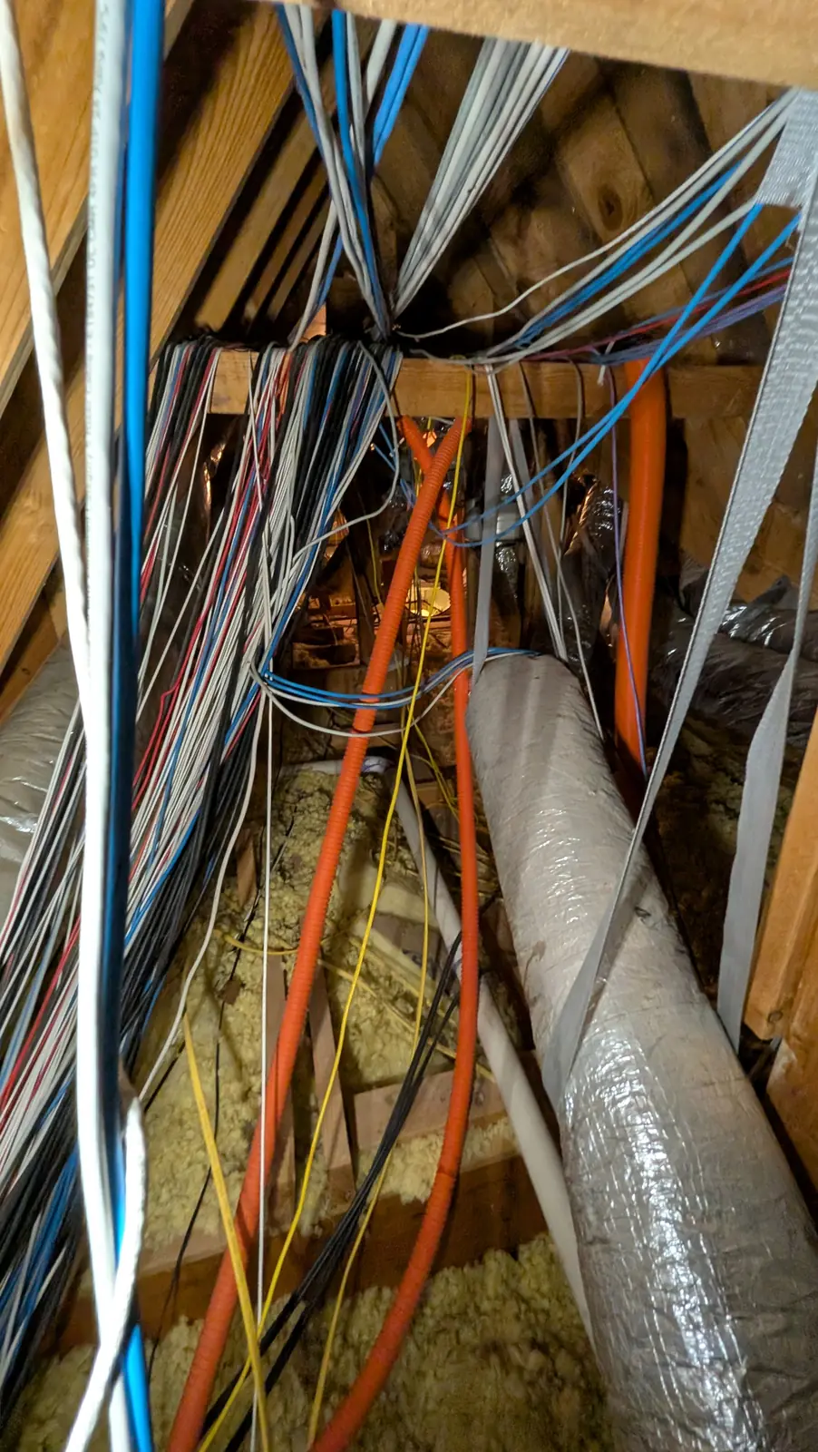 Multiple network cable runs pulled through an attic alongside insulated ductwork