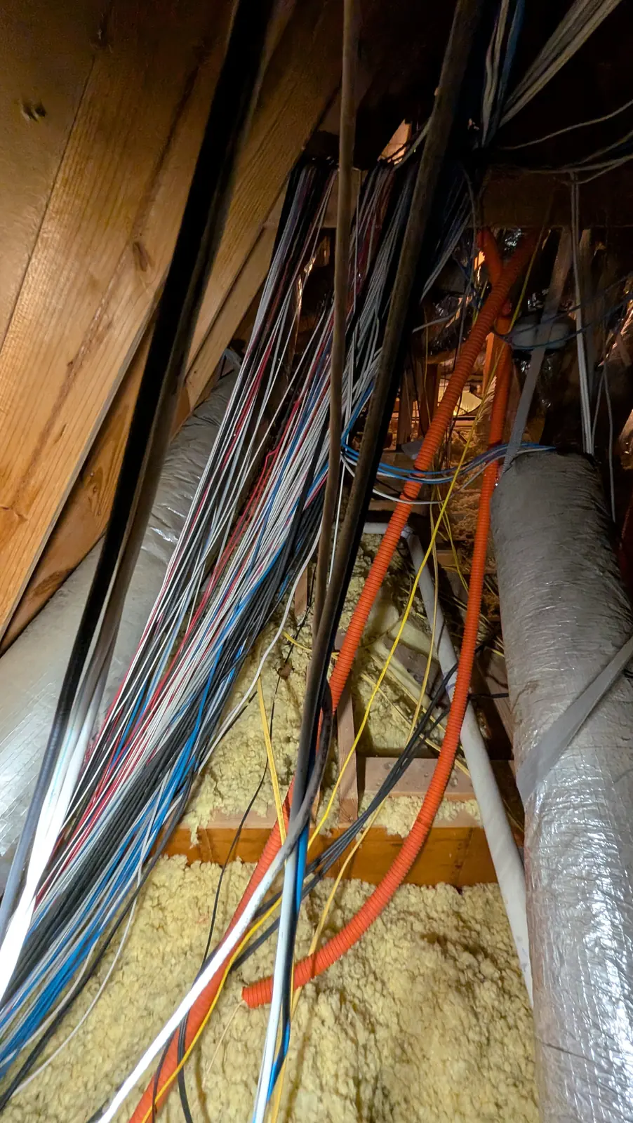 Cat6 and low-voltage cable bundles dropping through attic framing