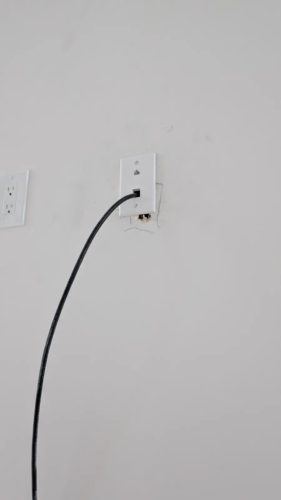 Finished wall-mounted network jack with patch cable connected