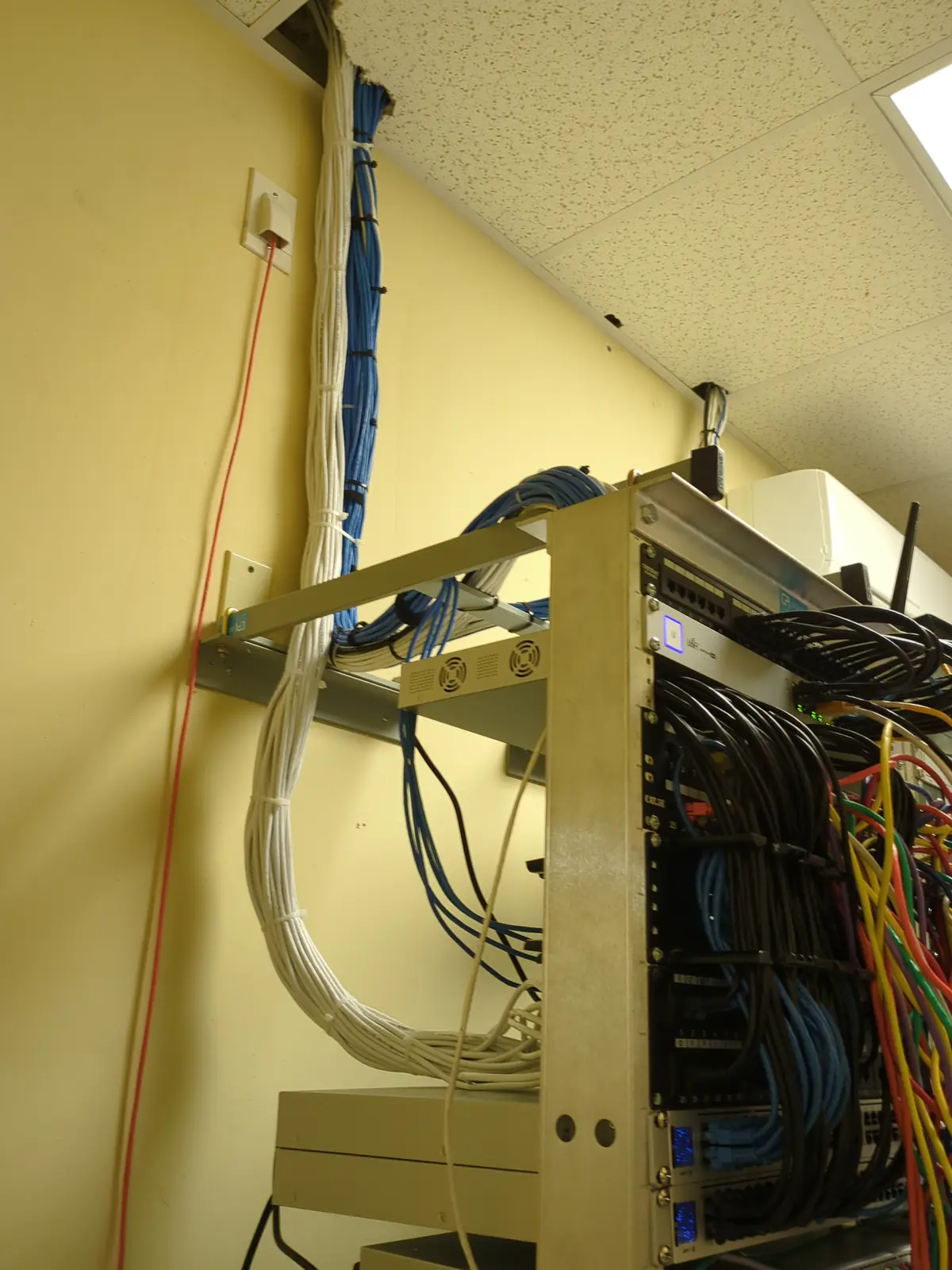 Open-frame network rack with patched cabling and cable trays in a server room