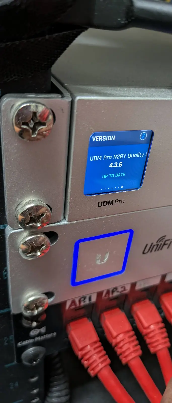 UniFi Dream Machine Pro gateway above a UniFi PoE switch with labeled red patch cables